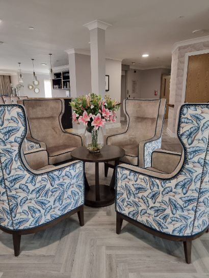 floral armchairs arranges in a circle in a care home reception